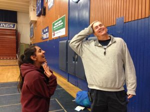 Mr. Strout showing off his clear-dyed hair while a student fangirls nearbyb.