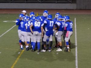 Sophomore quarterback Andrew Walker (#12) in the huddle explaining to his teammates the next offensive play. PC: Channing Whitaker  