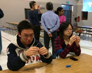 PC: Cathy Wang Caption: Freshman William Zhang and sophomore Connie Liang attempt to solve metal ring puzzles at the Pi Day Celebration.