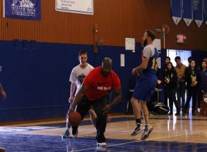 Algebra teacher Mr. Eddings dribbles the ball past senior Nate Schmitz as his teammate, PE teacher Mr. Jones, jumps aside (Cathy Wang).