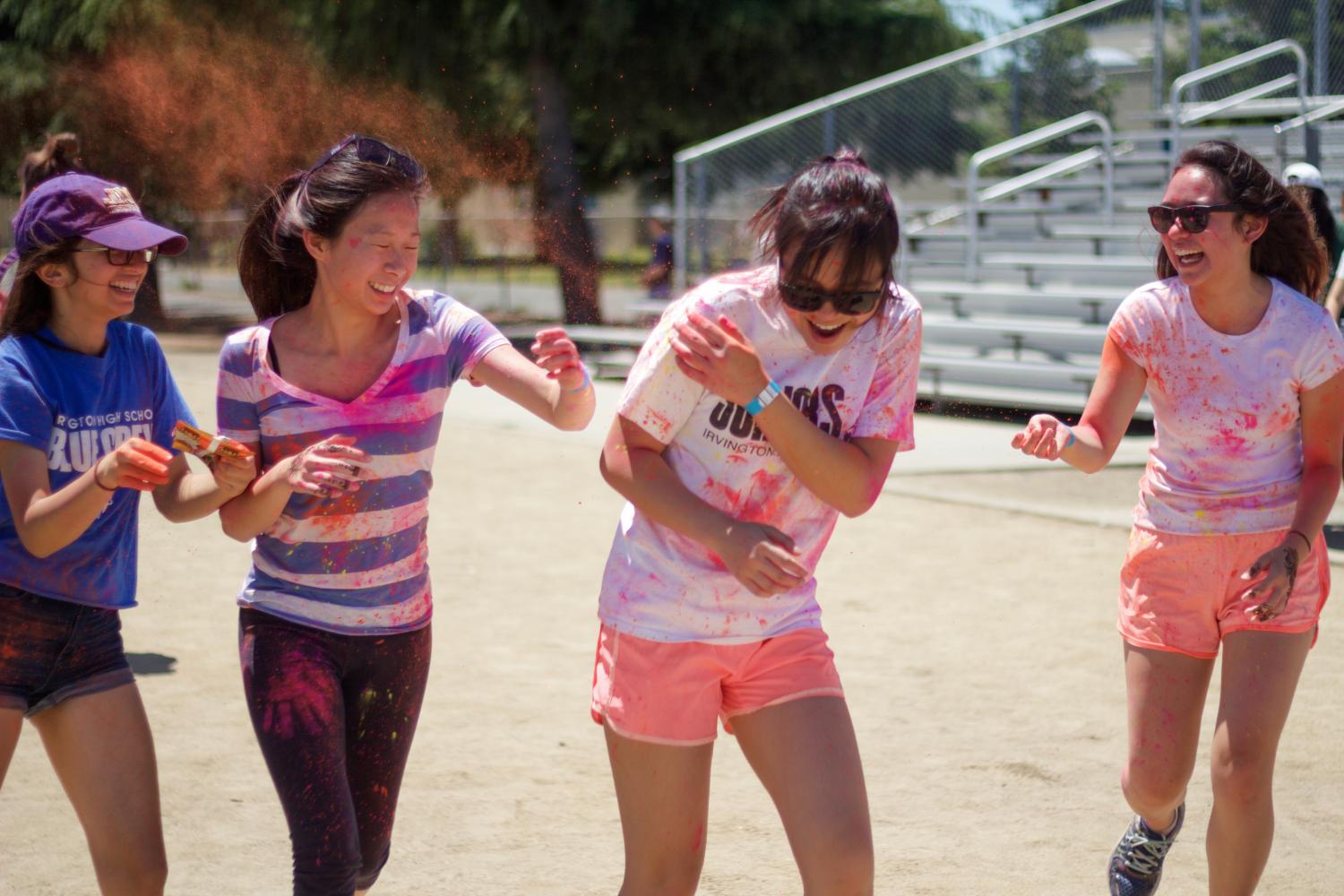 Sophomores+Saisha+Singh%2C+Mary+Tang%2C+Hannah+Limary%2C+and+Simone+Mendoza+throw+color+at+one+another+while+running+around+the+track.