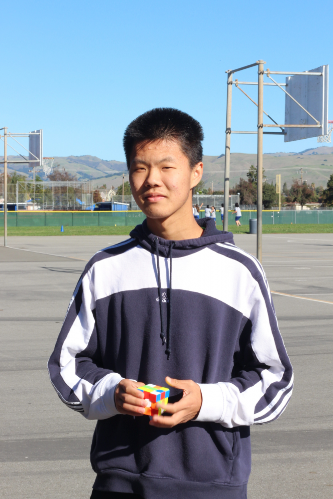 Zili pops his normal 3 by 3 cube out of his pocket and nonchalantly solves it a few times as he poses for his picture. 