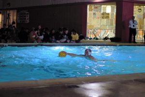 Captain Cade Ross (12) swims up the pool with the ball.
