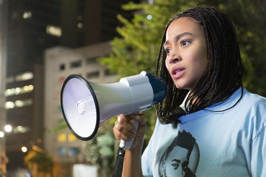 Amandla Stenberg as Starr Carter advocating for African-American rights in a protest.