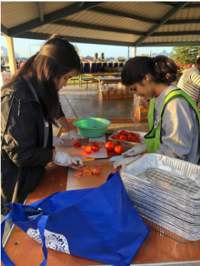 Vivian Ku (12) and Afra Raza (12) help chop vegetables.