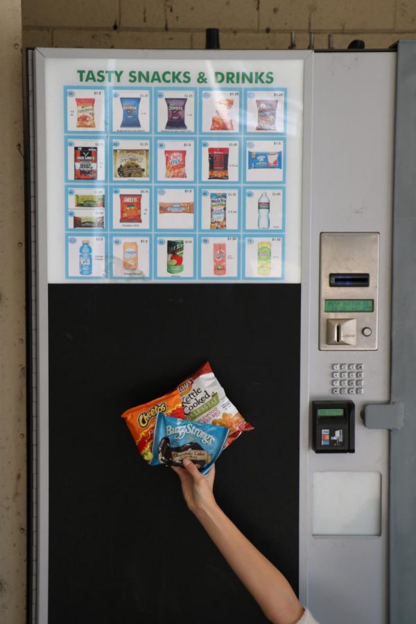 The top three snacks, Buzz Strong’s chocolate chip cookie, hot Cheetos, and kettle cooked potato chips in front of the vending machine they came from.