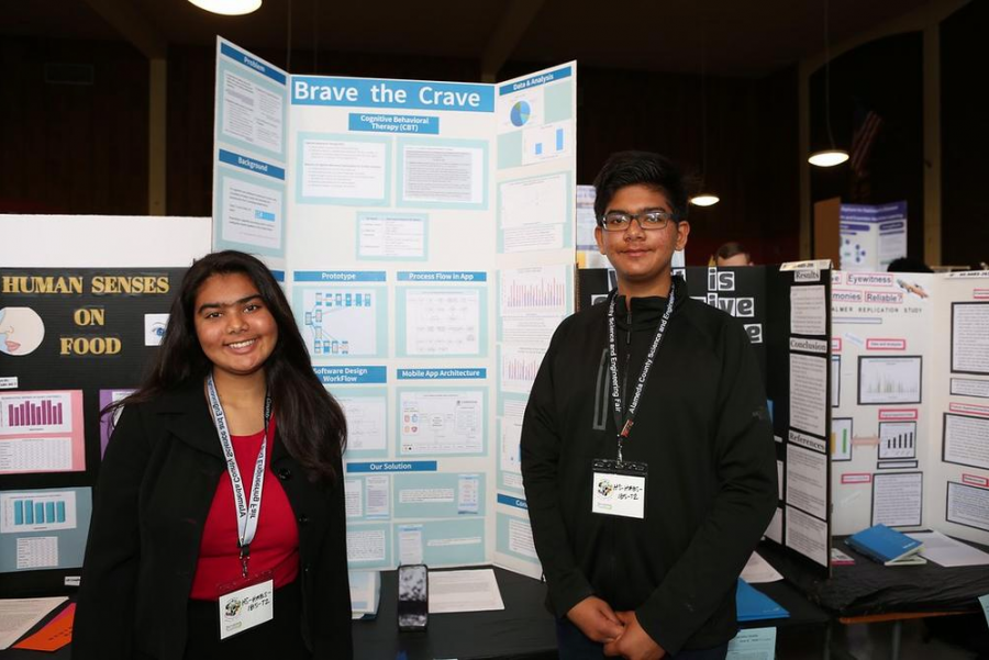 Aria Lakhmani (left) and Suyash Lakhmani (right) present their poster board on their “Brave the Crave” project at the Alameda County Science Fair.  (Editors Note: This photo was taken pre-quarantine. Please practice social distancing.)