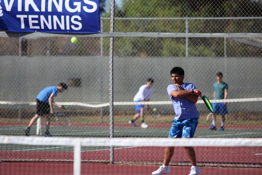 Team Captain Aryaman Gautam (11) hits a forehand. This photo was taken last season, pre-COVID.