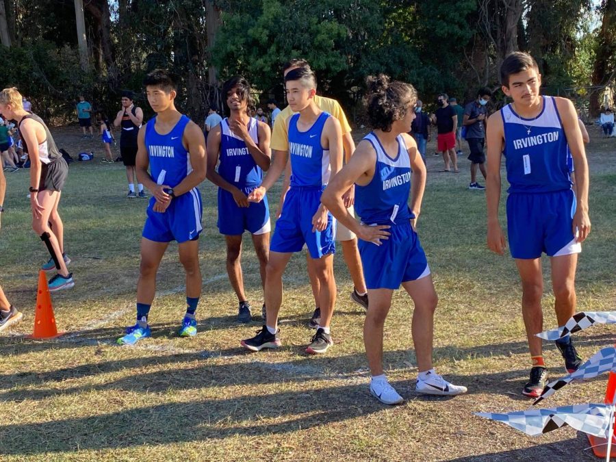 The+boys+varsity+team+surveys+their+opponents+and+stretches+before+their+center+meet.+Pictured+here+are+captains+Samuel+Forbes+%2812%29+and+Alex+Kwok+%2812%29.