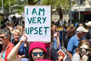 Woman hits the streets to declare that she is very upset.
