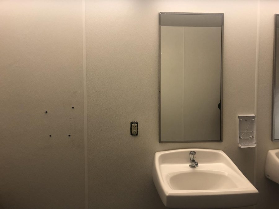 Damage in the new building's boys bathroom includes two stolen dispensers, and one unscrewed wall plate. 
