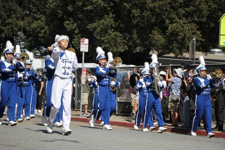 Varsity Drum Major Isabelle Hsu (11) directs students as they march across the parade. 
Photo credit: IHS Vikings Music Boosters
