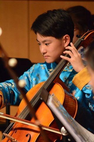 Sunny Liu (12) playing cello for orchestra.