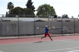 Aryaman Gautam (12) hits a strong forehand stroke, in his match against Logan High School’s Varsity 1 opponent.