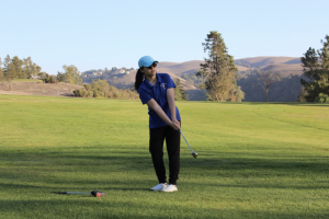 Golfer Jacquelyn Chen (12) swings her golf club.