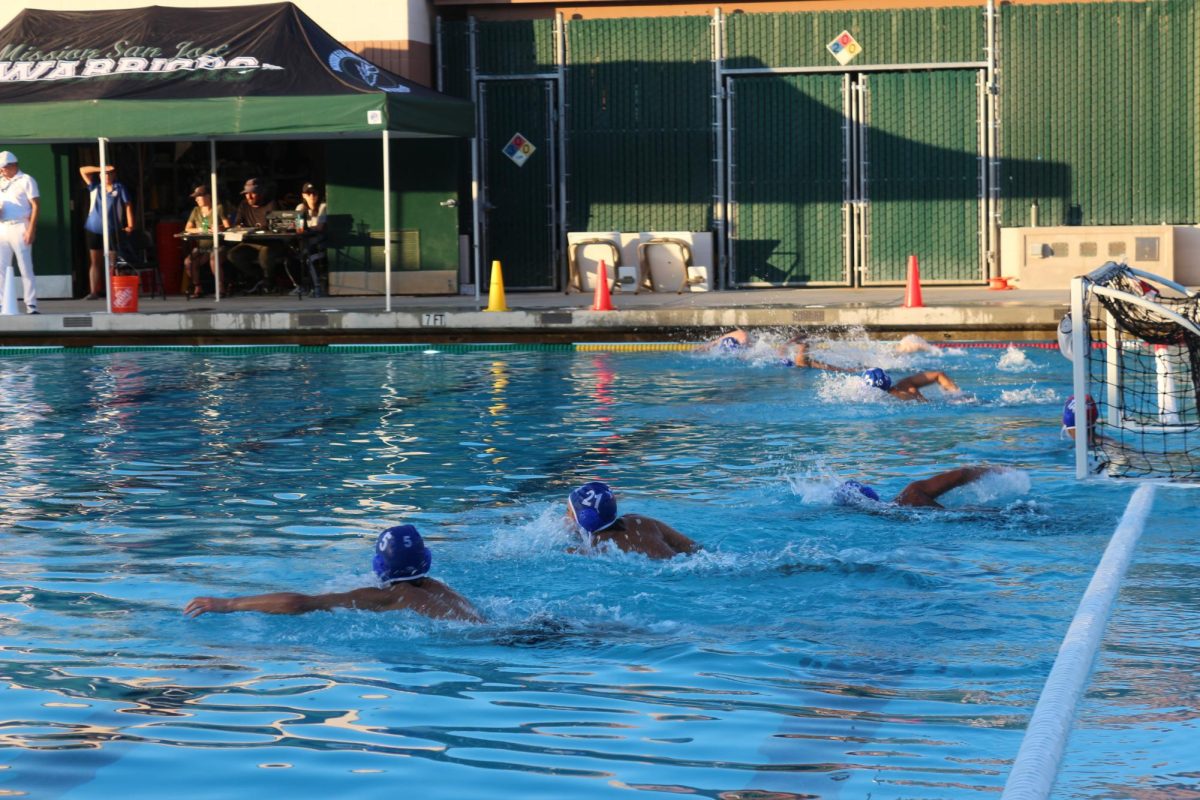 The boys team rushes forward to steal the ball from the other team.