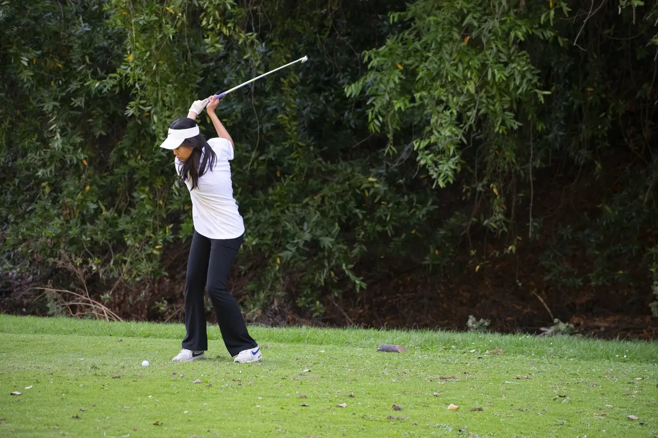 Irvington Girls Golf player Alice Wu tees up, ready to strike the golf ball.