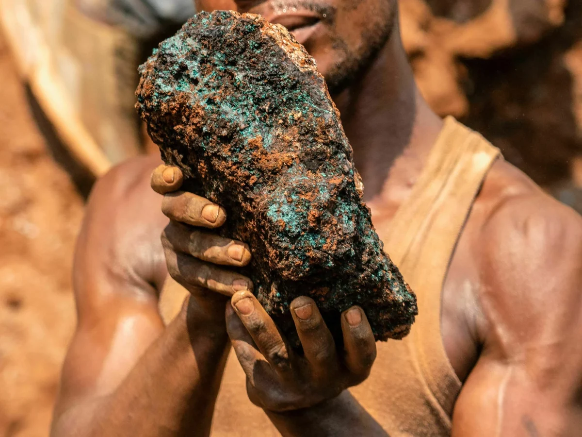 A miner holds up a block of cobalt.