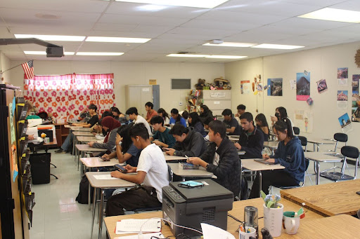 Students watch an informational video on school shootings on their phones. 
