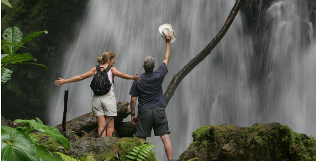 Couple stands in front of a waterfall after ecotourism adventure
 
Image Credit: Natural Habitat Adventures
