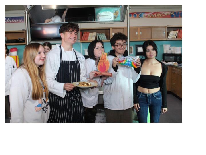 A group poses for the camera, showcasing their S’mores cookies. 