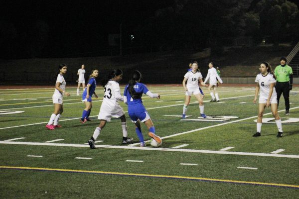 Riya Patel (11) carries the ball smoothly past defenders.