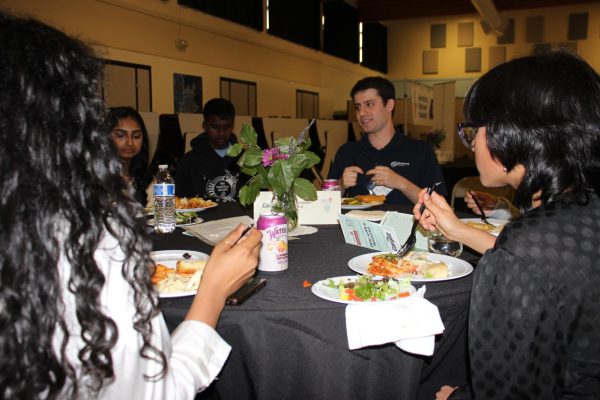 Students converse with a professional scientist at Girls in STEM club's Dine with a Scientist event.