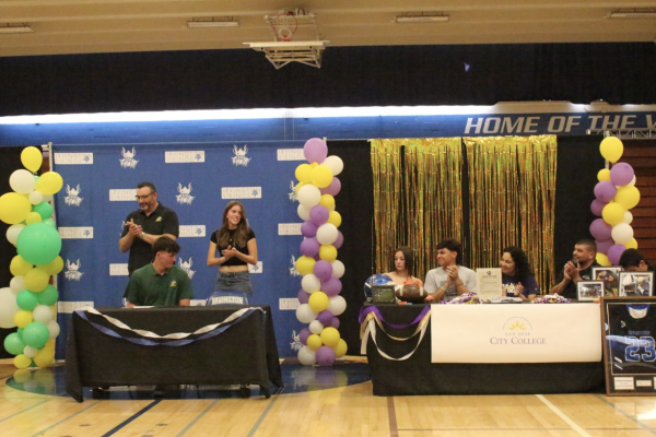 Parents and loved ones gather around the signing table as Jaksa and Forbes commit to their respective schools.