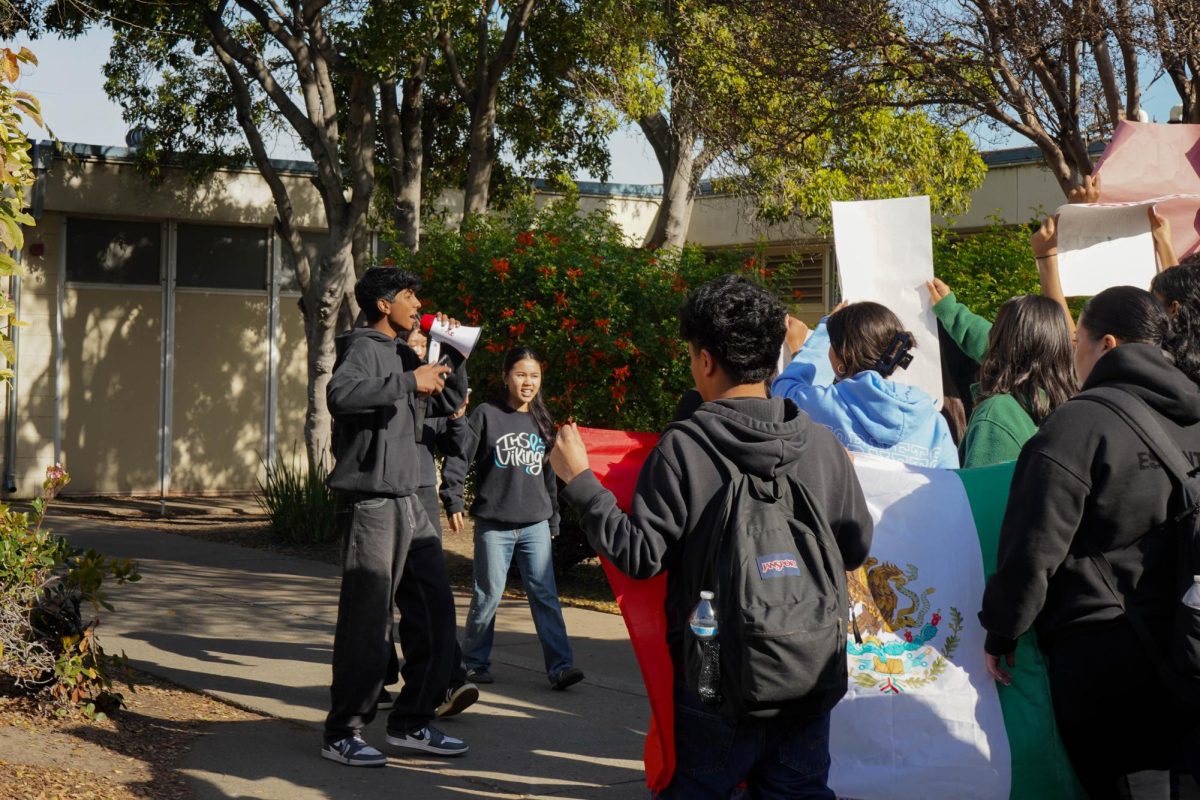 Students Jay Bhimani (11) and Michelle Nguyen (12) lead a student group marching around campus. - Guest Contributor 