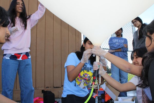 Members of the BalloonSat team inflate the balloon and prepare it for launch.
